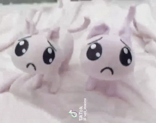 Gif of two p-chan plushies with rainbow lighting. The camera is being moved to make it look like they are dancing.